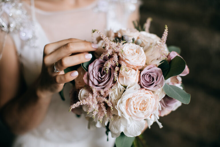 The bride holds a beautiful wedding bouquet of pink and white fl
